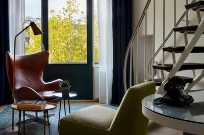 a living room with a chair and a table and a window at Park Centraal Amsterdam, part of Sircle Collection in Amsterdam