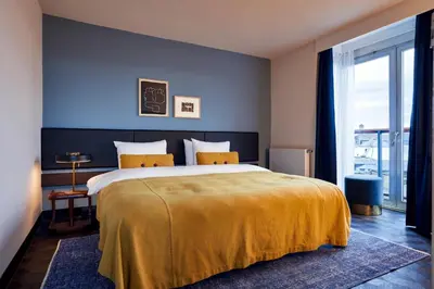 a bedroom with a large bed with a yellow blanket at Park Centraal Amsterdam, part of Sircle Collection in Amsterdam