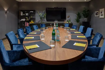 a conference room with a long wooden table and blue chairs at Park Centraal Amsterdam, part of Sircle Collection in Amsterdam
