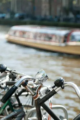 a group of bikes parked next to a river with a boat at Banks Mansion - Boutique Hotel in Amsterdam
