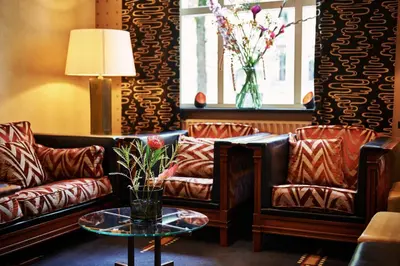 a living room with two leather couches and a table at Banks Mansion - Boutique Hotel in Amsterdam
