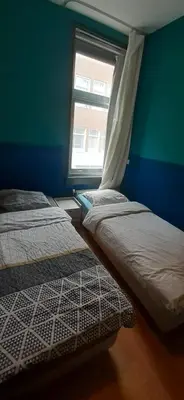 two beds in a room with a window at CHARLOTTE, not for parties, not a hotel, room with shared bathroom, no kitchen in Amsterdam
