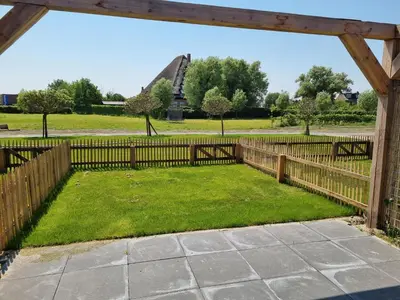 a garden with a fence and a park in the background at DW Castricum in Castricum