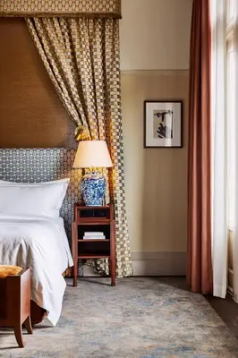 a bedroom with a bed and a table with a lamp at De L’Europe Amsterdam – The Leading Hotels of the World in Amsterdam