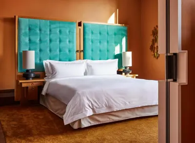 a bedroom with a large white bed with a blue headboard at De L’Europe Amsterdam – The Leading Hotels of the World in Amsterdam