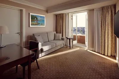 a living room with a couch and a table at Van der Valk Palace Hotel Noordwijk in Noordwijk aan Zee