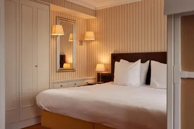 a bedroom with a large bed and a mirror at Van der Valk Palace Hotel Noordwijk in Noordwijk aan Zee