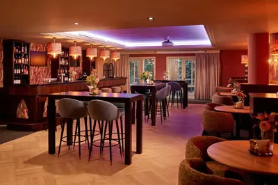 a bar in a restaurant with tables and chairs at Van der Valk Palace Hotel Noordwijk in Noordwijk aan Zee