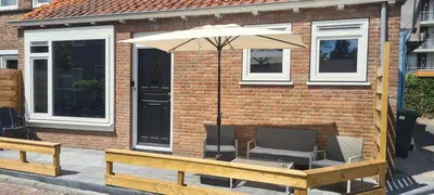 a patio with an umbrella and two chairs and a table at The Flower Fields in Lisse