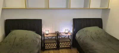 two beds in a room with a table between them at The Flower Fields in Lisse