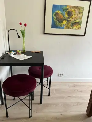 a table with two chairs and a vase with flowers at BeBaBops Homestay Utrecht in Utrecht