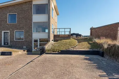a brick building with a brick walkway next to a building at Vernieuwd Zeezicht Villa Duin Suite in Bergen aan Zee