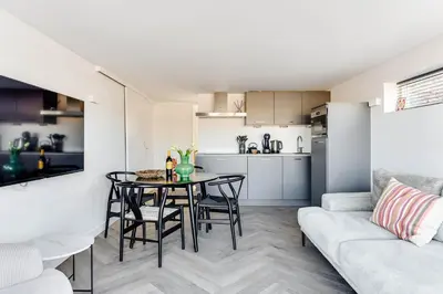 a living room and kitchen with a table and chairs at Vernieuwd Zeezicht Villa Duin Suite in Bergen aan Zee