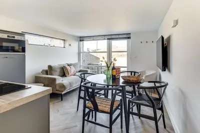 a kitchen and living room with a table and chairs at Vernieuwd Zeezicht Villa Duin Suite in Bergen aan Zee
