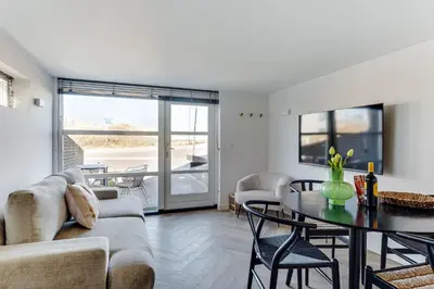 a living room with a couch and a table at Vernieuwd Zeezicht Villa Duin Suite in Bergen aan Zee