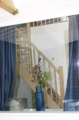 a blue vase with purple flowers in a window at De Bosrand grenzend aan het bos in Castricum