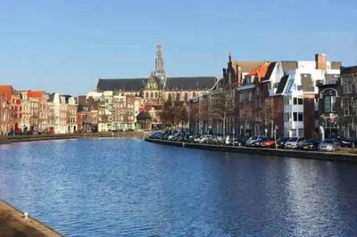 a river in a city with buildings and cars at Appartement met tuin in Haarlem centrum(Vijfhoek) in Haarlem