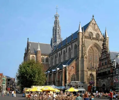 a large building with tables and umbrellas in front of it at Appartement met tuin in Haarlem centrum(Vijfhoek) in Haarlem