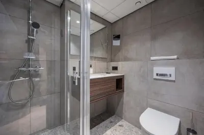 a bathroom with a shower and a toilet and a sink at Postillion Utrecht Bunnik in Bunnik