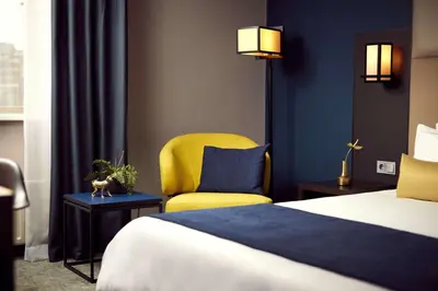 a hotel room with a bed and a yellow chair at Park Plaza Utrecht in Utrecht
