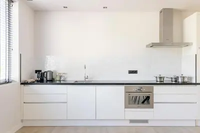 a white kitchen with a sink and a stove at SéSé in Vinkeveen