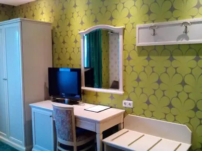 a room with a desk with a computer and a mirror at Hotel Zwanenburg Amsterdam Airport in Zwanenburg