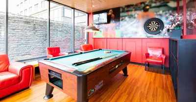a billiard room with a pool table and two chairs at Bastion Hotel Almere in Almere