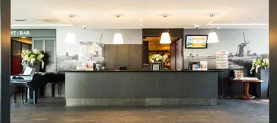 a bar in a restaurant with tables and chairs at Best Western Plus Amsterdam Airport Hotel in Hoofddorp