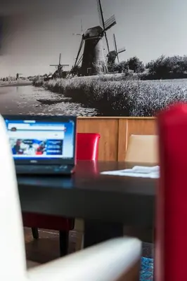 a laptop computer sitting on a table with a windmill at Best Western Plus Amsterdam Airport Hotel in Hoofddorp