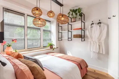 a bedroom with a bed and a window and lights at Boutique Studio Amsterdam near RAI and De Pijp in Amsterdam