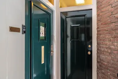 a pair of green doors on a brick building at Boutique Studio Amsterdam near RAI and De Pijp in Amsterdam