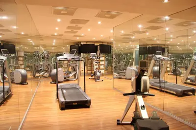 a gym with several tread machines and mirrors at Bastion Hotel Amsterdam Amstel in Amsterdam