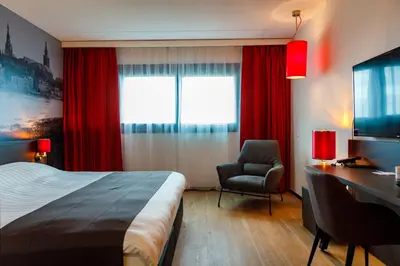 a hotel room with a bed and a desk and a chair at Bastion Hotel Amsterdam Amstel in Amsterdam