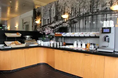 a restaurant with a counter with food on it at Bastion Hotel Amsterdam Noord in Amsterdam