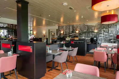 a dining room with tables and chairs and a restaurant at Bastion Hotel Amsterdam Noord in Amsterdam
