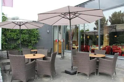 a couple of tables and chairs with umbrellas at Bastion Hotel Amsterdam Noord in Amsterdam