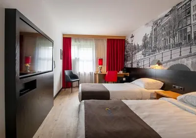 a hotel room with two beds and a television at Bastion Hotel Amsterdam Noord in Amsterdam