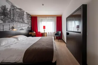 a hotel room with a large bed and a television at Bastion Hotel Amsterdam Zuidwest in Amsterdam