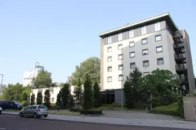 a car parked in front of a white building at Bastion Hotel Amsterdam Zuidwest in Amsterdam