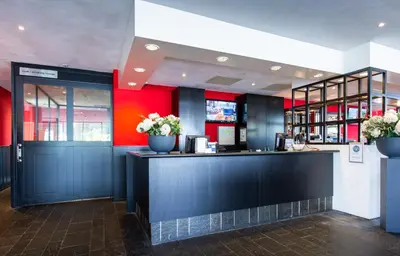 a restaurant with a black counter and red walls at Bastion Hotel Zaandam in Zaandam