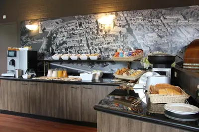 a buffet line with bread and pastries in a restaurant at Bastion Hotel Bussum Hilversum in Bussum