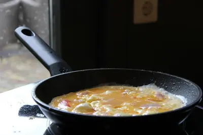 a pan filled with food on a stove at Bastion Hotel Bussum Hilversum in Bussum