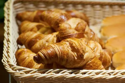 a basket filled with croissants and a croissant at Bastion Hotel Haarlem Velsen in Santpoort-Noord
