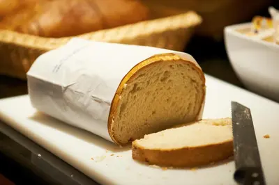 a piece of bread on a plate with a knife at Bastion Hotel Haarlem Velsen in Santpoort-Noord