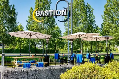 a group of tables and chairs with umbrellas at Bastion Hotel Haarlem Velsen in Santpoort-Noord