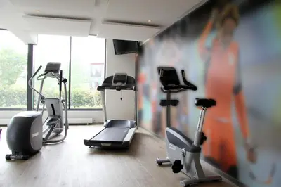 a gym with several exercise equipment in a room at Bastion Hotel Haarlem Velsen in Santpoort-Noord