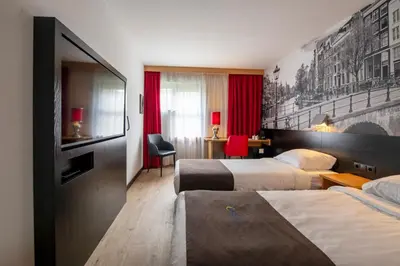 a hotel room with two beds with red curtains at Bastion Hotel Leiden Oegstgeest in Oegstgeest