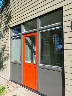 an orange door and windows on a house at Bollenboet in Sint Maarten