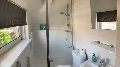 a bathroom with a shower and a toilet and a sink at 'Onder-dak' 2-persoons appartement in Zandvoort