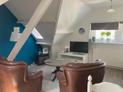 a living room with a table and two chairs at 'Onder-dak' 2-persoons appartement in Zandvoort